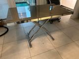 a table that has a glass top and a metal base