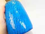 une personne tenant un vase bleu à la main