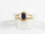 une image d'une bague en or avec une pierre bleue et des diamants