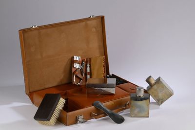 a brown suitcase with tools in it on a white surface