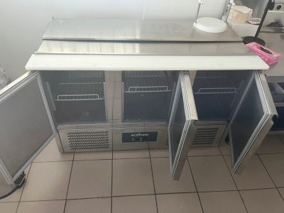 une photo d'une cuisine avec un réfrigérateur et un plan de travail