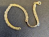 gros plan d'un bracelet en or sur une surface noire