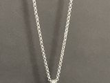 a silver necklace with a flower pendant on a chain
