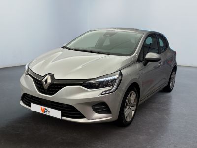 La voiture argentée est garée dans une pièce au sol noir.