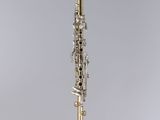 a close up of a silver and gold clarinet on a stand