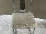 a chair with a seat made of sheepskin and a metal frame