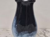 un vase noir et blanc posé sur une table en marbre