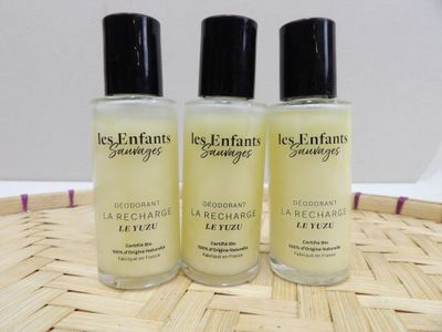 three bottles of perfume sitting on top of a bamboo mat