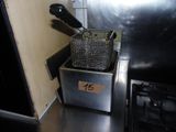 une image représentant une friteuse dans laquelle est planté un couteau
