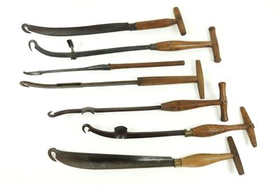 several different types of knives are lined up on a white surface
