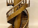 une sculpture en bois représentant un escalier en colimaçon posée sur un socle