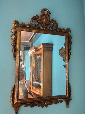 a mirror hanging on the wall above a cabinet