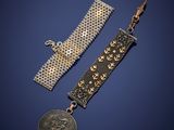 deux bracelets en or et en argent et une pièce de monnaie sur fond bleu
