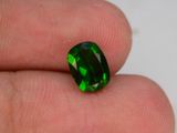 Quelqu'un tient une tourmaline verte dans la main.