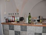 a counter with bottles of alcohol and a clock on the wall