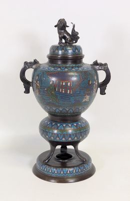 un vase bleu surmonté d'une statuette