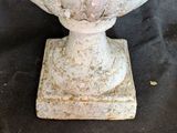 a white vase sitting on top of a black table