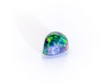 a close up of a green and blue oplite stone on a white surface