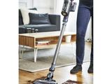 une femme en train de nettoyer un parquet avec un aspirateur sans fil