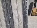 de nombreux rouleaux de matelas emballés dans du plastique dans un entrepôt
