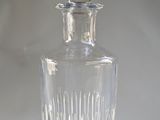 a clear glass bottle with a stopper sitting on a table