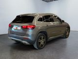 the rear end of a silver mercedes suv parked in a showroom