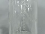a clear glass bottle with a silver lid on a table