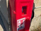 une borne d'incendie rouge posée au bord de la route