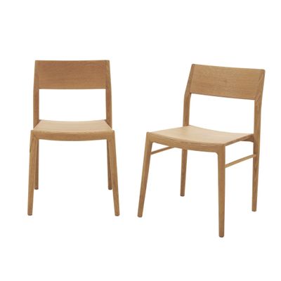 deux chaises en bois assises l'une à côté de l'autre sur une surface blanche
