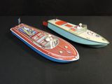 deux petits bateaux jouets posés côte à côte sur une surface noire