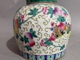 a white vase with colorful flowers on it sitting on a table