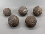 quatre boules métalliques posées les unes à côté des autres sur une table