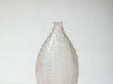 a glass vase that is sitting on a white surface