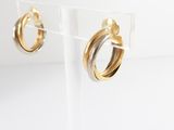 two tone hoop earrings in gold and silver on clear acrylic stand