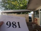 une personne tenant un bout de papier devant une maison