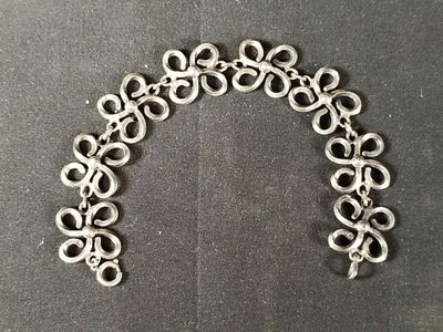 an image of a bracelet made out of metal rings on a black surface