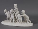 a statue of a group of children playing with a dog