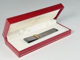 a red box with a pen in it on a white surface