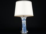 une lampe de table bleue et blanche surmontée d'un abat-jour blanc