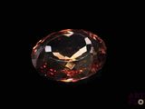 a close up view of a large orange diamond on a black background