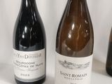 three bottles of wine are lined up on a white surface