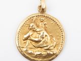 a close up of a gold coin with a woman on it