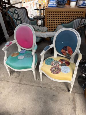 Deux chaises colorées sont placées devant une table et une chaise.