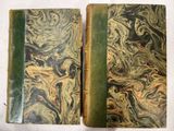 un vieux livre à la couverture verte posé sur une table blanche