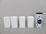 quatre boîtes blanches ornées de motifs en noir et blanc, disposées les unes à côté des autres
