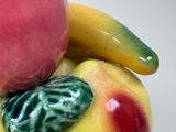 apples and bananas are stacked on top of each other on a white surface