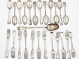 a lot of spoons and forks laid out on a table