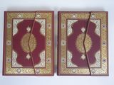 two red and gold book covers with intricate designs on them