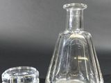 a glass bottle and a glass cup on a table