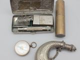 un étui en argent contenant un briquet et d'autres objets, posé sur une table